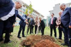 Rektör Özkan, İlahiyat Fakültesi’nde ağaç dikiyor ve Gazze sergisini inceliyor.