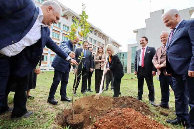 Rektör Özkan, İlahiyat Fakültesi’nde ağaç dikiyor ve Gazze sergisini inceliyor.